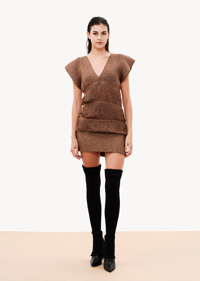 A comfy fit that is close to the silhouette, it is sleeveless with lowered cap-style shoulders, its design has layered strands that are connected with fringes, it is lined with elastic tulle, it closes at the back with a button of the same yarn