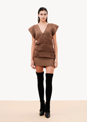 A comfy fit that is close to the silhouette, it is sleeveless with lowered cap-style shoulders, its design has layered strands that are connected with fringes, it is lined with elastic tulle, it closes at the back with a button of the same yarn