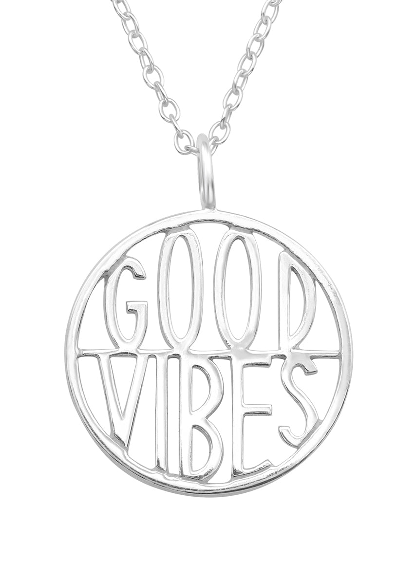 A silver necklace with a round pendant that reads 'GOOD VIBES'.