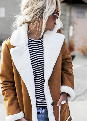 Woman wear a brown shearling coat with white collar and cuff details