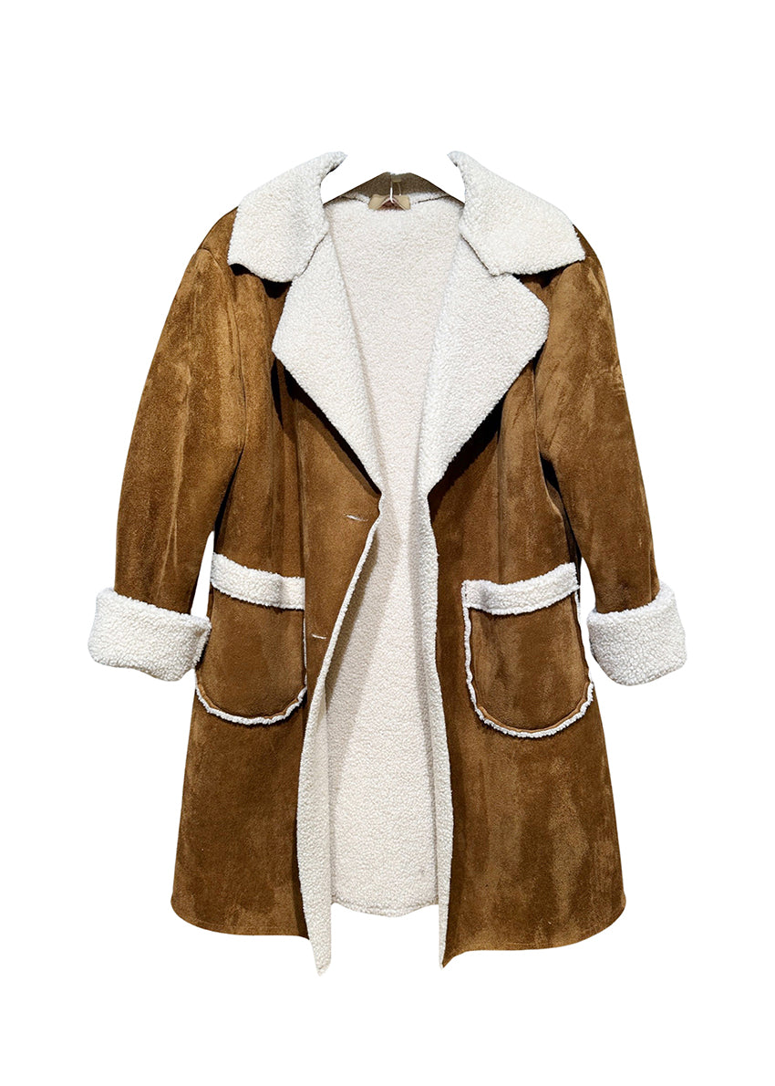 Woman wear a brown shearling coat with white collar and cuff details