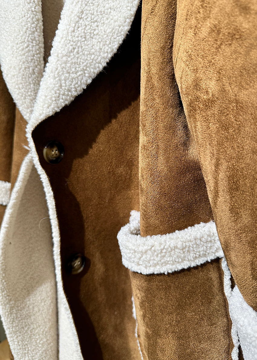 A brown shearling coat with white collar and cuff details