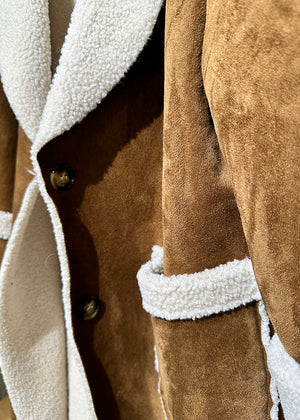 A brown shearling coat with white collar and cuff details