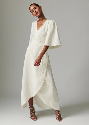 Woman wearing a white dress with a plain background