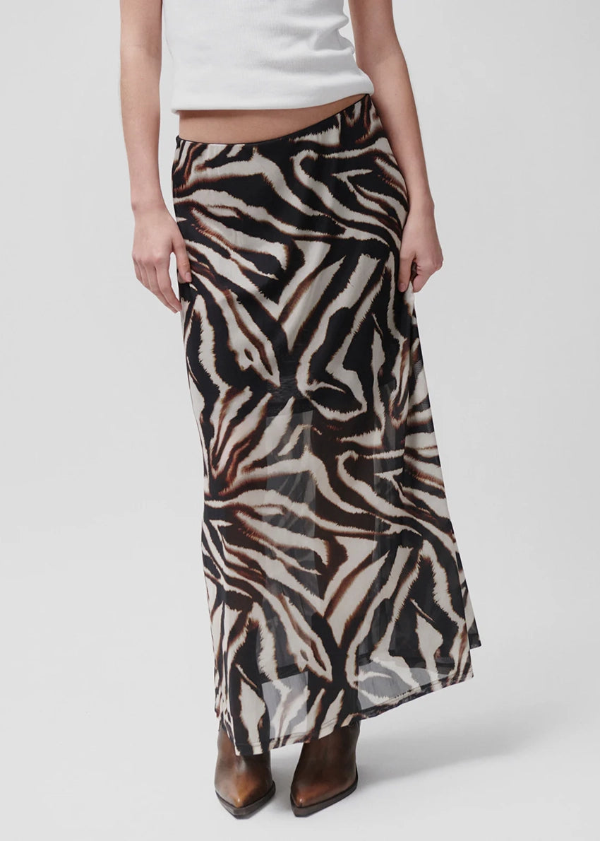 Person wearing a zebra print skirt on a white background