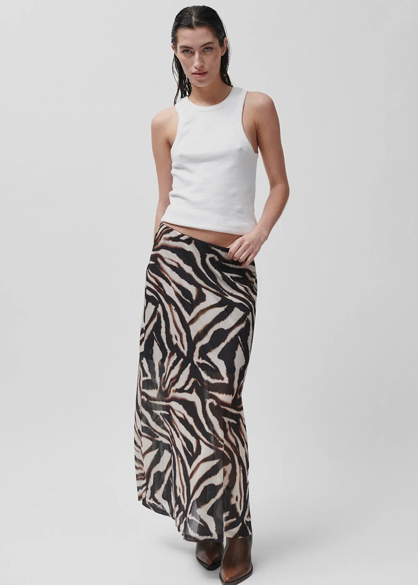 Person wearing a zebra print skirt on a white background