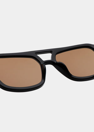Black sunglasses with brown lenses on a light gray background