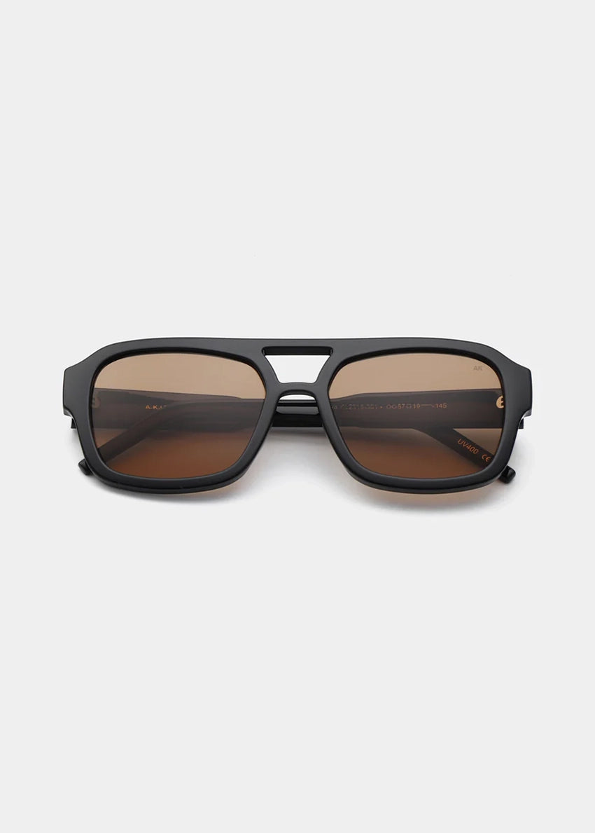 Black sunglasses with brown lenses on a white background