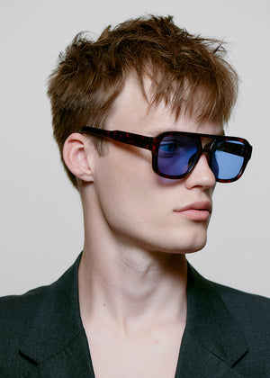 Person wearing sunglasses with a neutral background