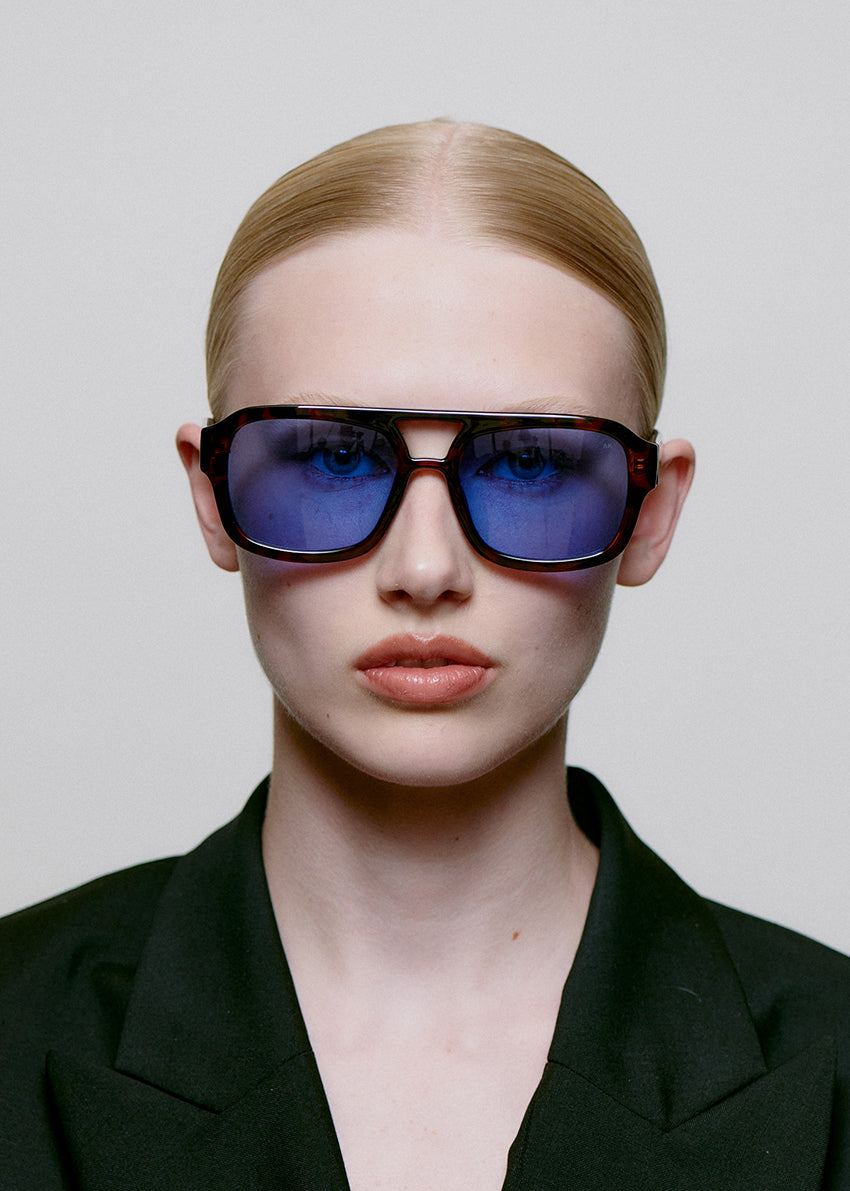 Person wearing sunglasses with a neutral background