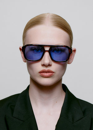Person wearing sunglasses with a neutral background