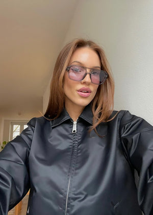 Person wearing a dark gray raincoat indoors
