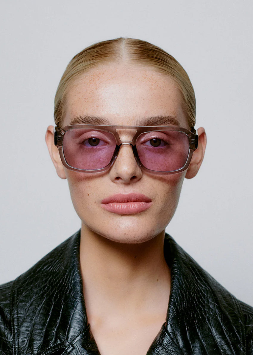 Sunglasses with a gray frame and purple lenses on a white background