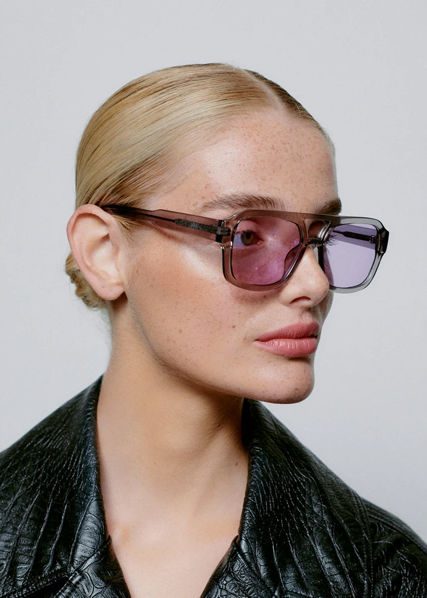 Person wearing sunglasses with a plain background