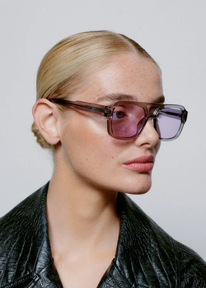 Person wearing sunglasses with a plain background