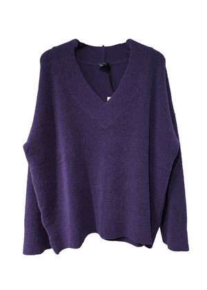 Wide knitted blue top, with a V rib neckline and ribbed cuffs, made of fluffy blended wool yarn.
