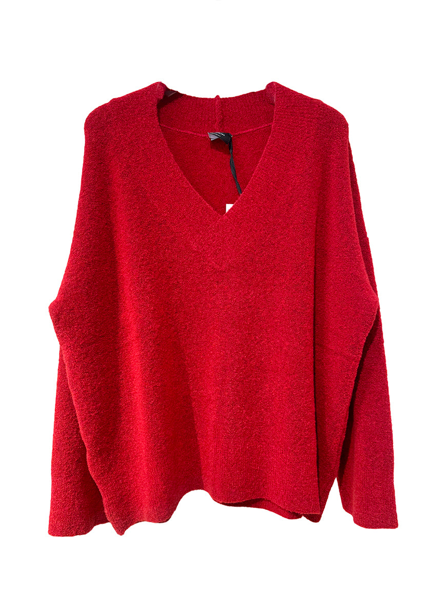 Wide knitted red top, with a V rib neckline and ribbed cuffs, made of fluffy blended wool yarn.