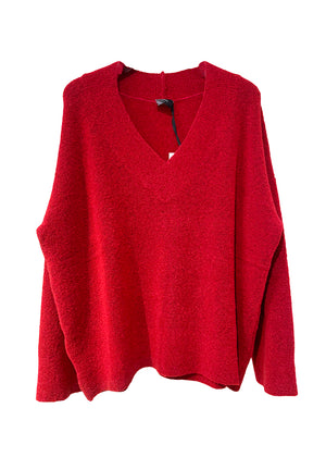Wide knitted red top, with a V rib neckline and ribbed cuffs, made of fluffy blended wool yarn.