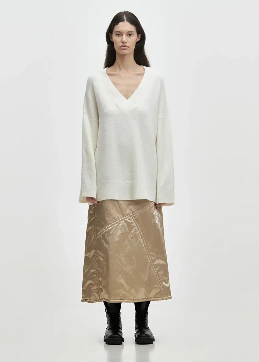 Wide knitted white top, with a V rib neckline and ribbed cuffs, made of fluffy blended wool yarn.