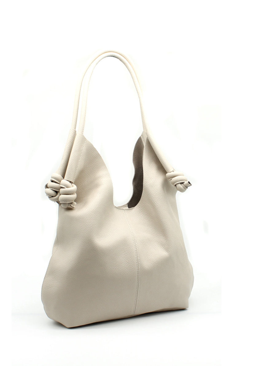 Light beige shoulder bag with a soft textured finish, featuring unique knotted straps. A chic and versatile accessory suitable for daily use