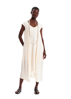 Person wearing a white sleeveless dress on a white background