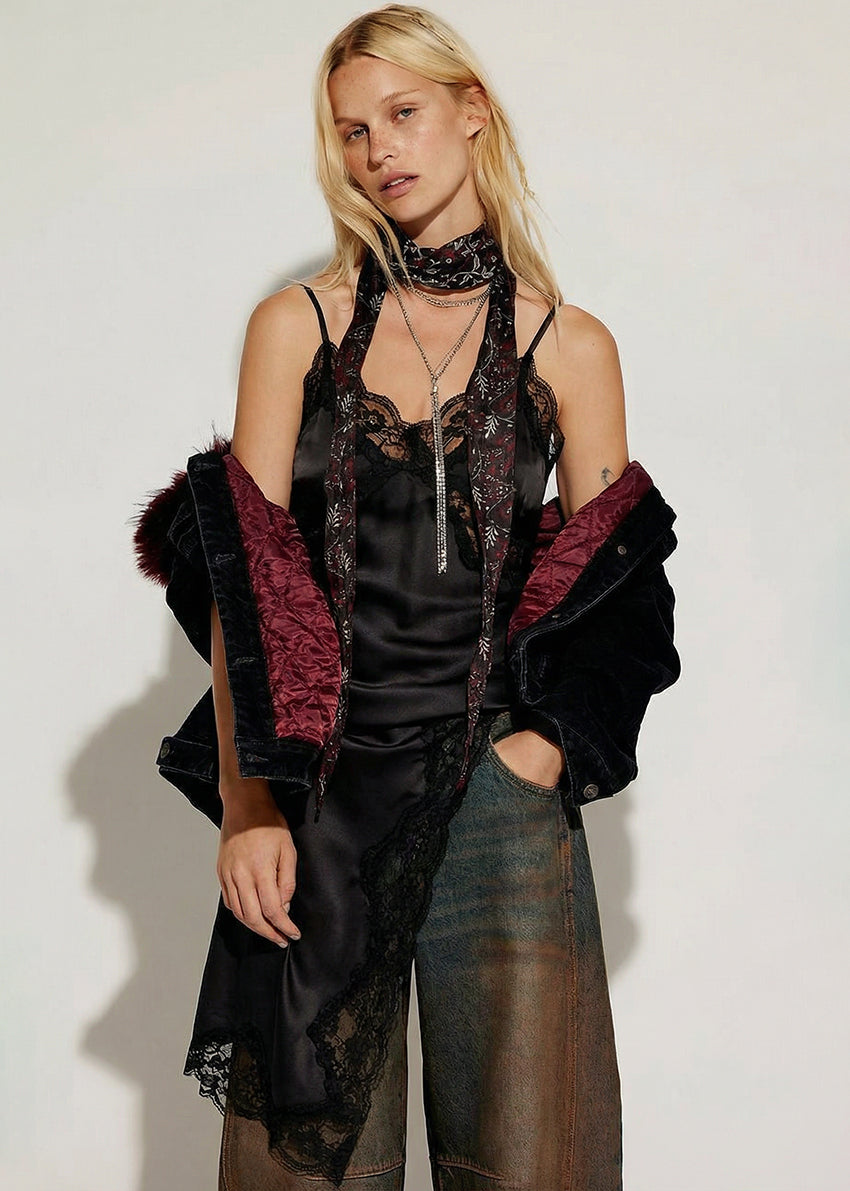 Woman wearing a black and red outfit with a sheer overlay against a white background