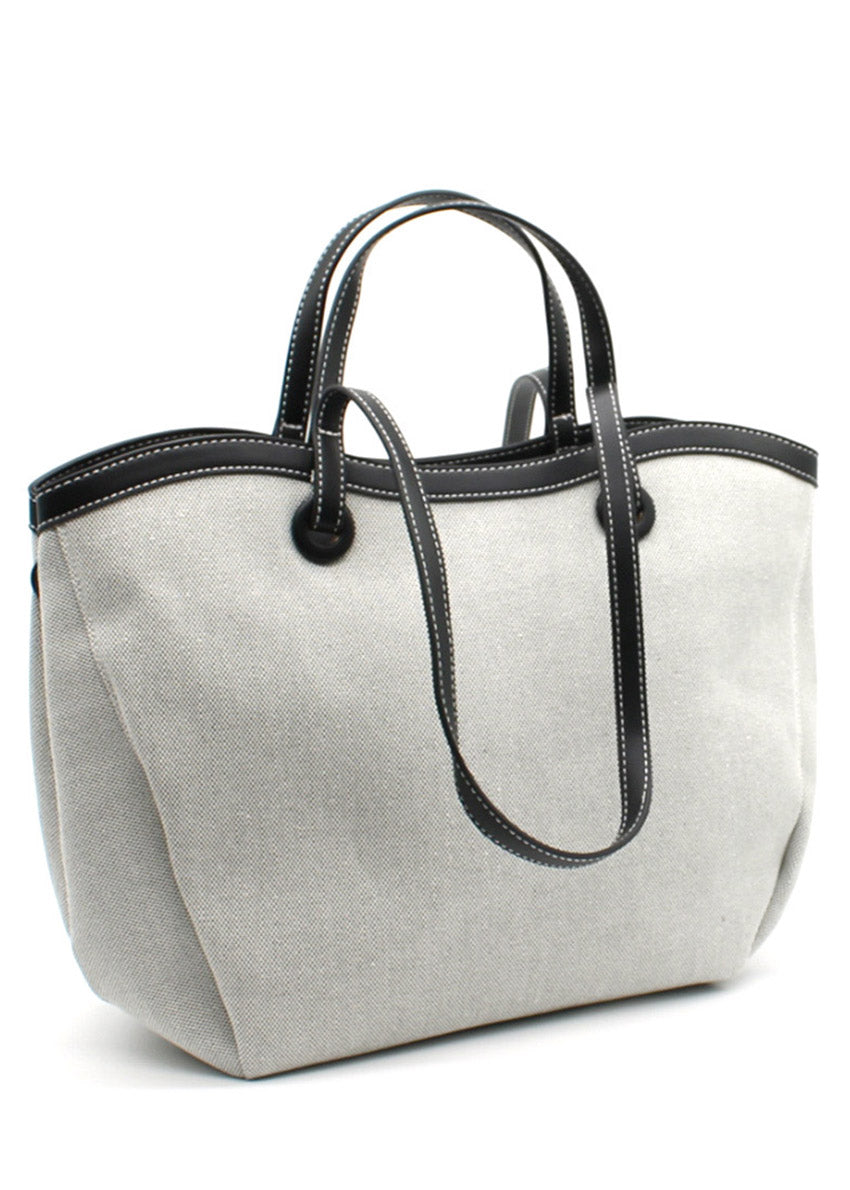 A black Lamorinda bag with brown leather-like details and a zipper closure.