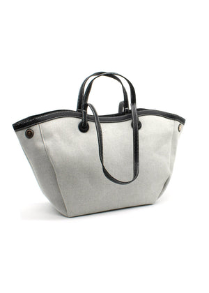 A beige Lamorinda bag with black leather-like details and a zipper closure.