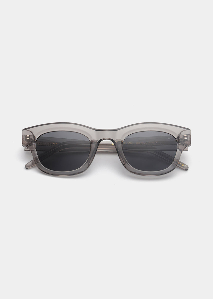 Sunglasses with a transparent frame and dark lenses on a white background