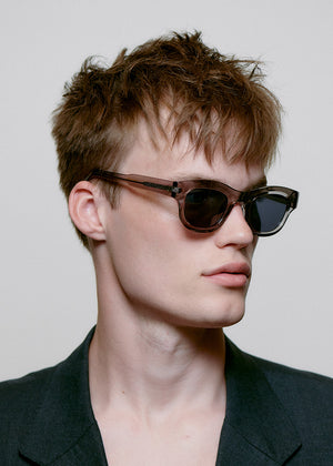 Sunglasses with a transparent frame and dark lenses on a white background