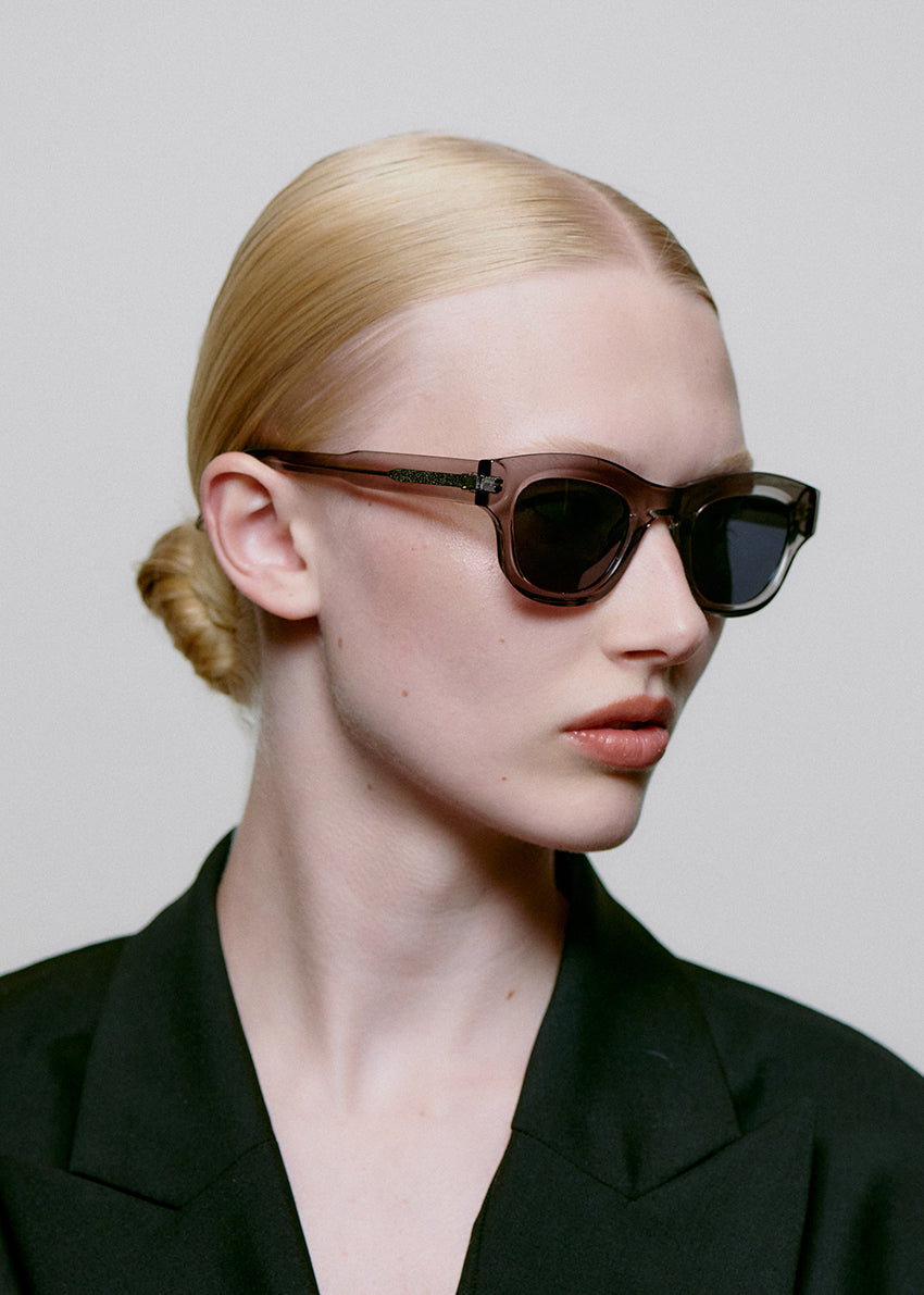 Sunglasses with a transparent frame and dark lenses on a white background