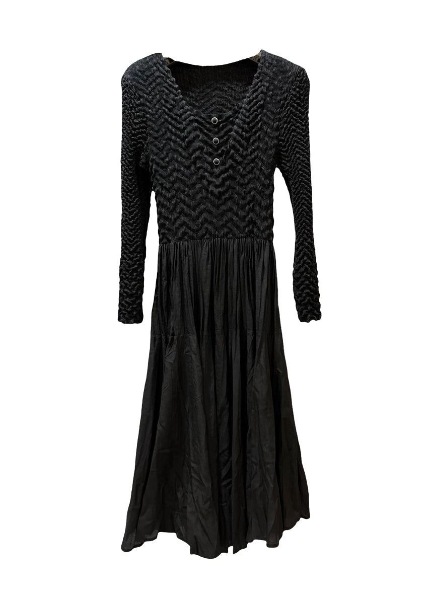 A black crepe dress with a fitted top and voluminous skirt, featuring straight and pleated long sleeves, photographed against a white background.