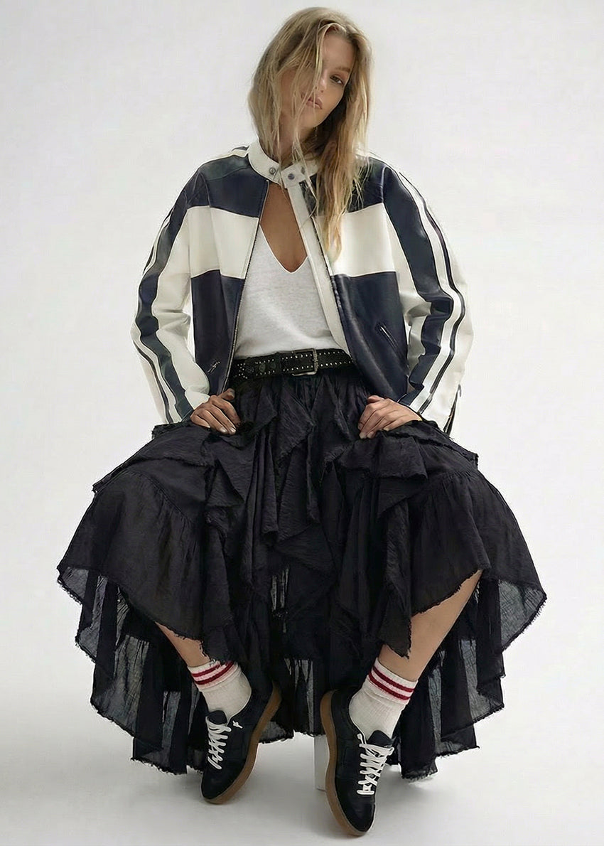 A stylish, contemporary outfit featuring a lightweight black-and-white jacket layered over a relaxed white top. The look is completed with a flowing black skirt, sporty socks, and lace-up shoes, creating a perfect blend of casual and edgy elegance.