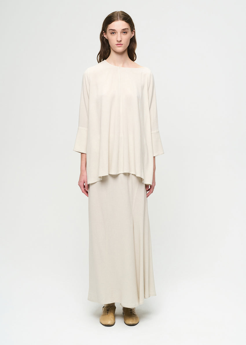 Woman wearing a cream-colored outfit on a white background