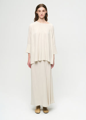 Woman wearing a cream-colored outfit on a white background