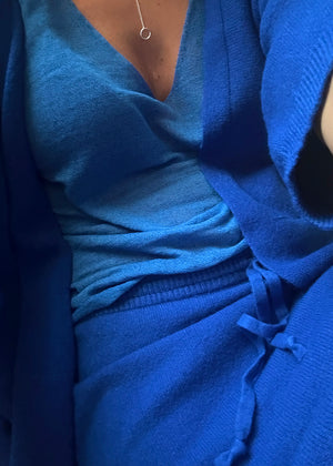 A person wearing a blue top with a blue skirt