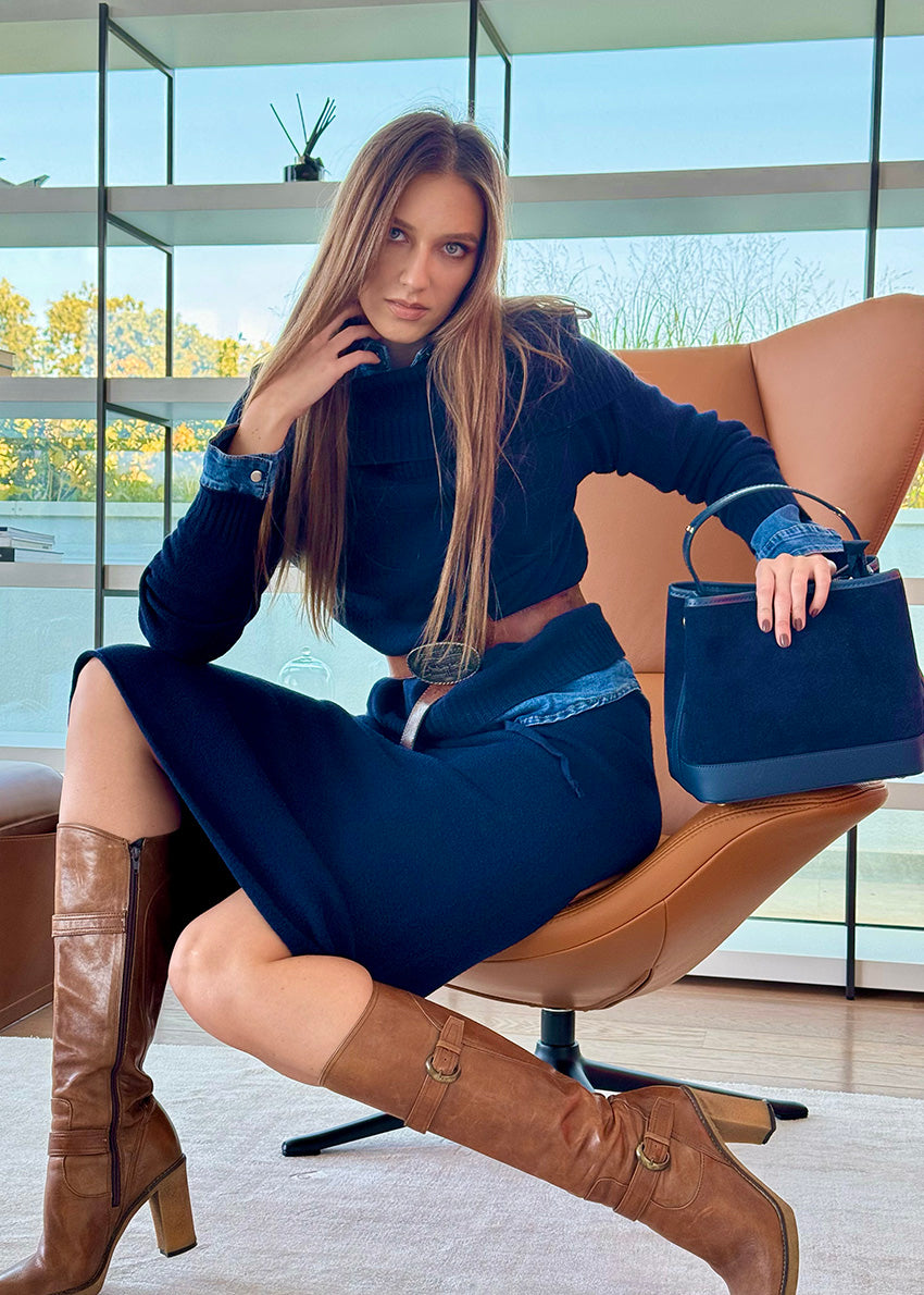 A person wearing a midnight blue sweater with a matching skirt