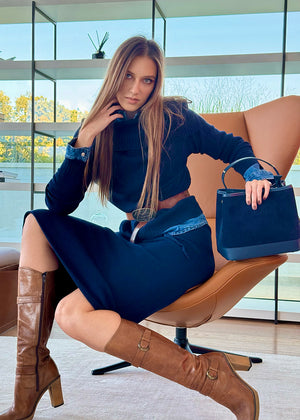 A person wearing a midnight blue sweater with a matching skirt