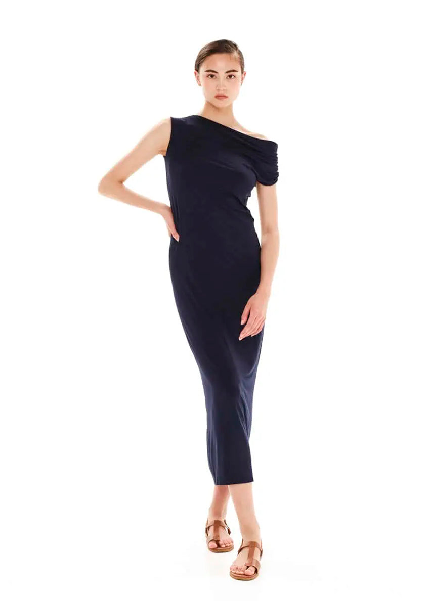 A woman wearing a black, one-shoulder, straight-fit midi dress with draping on the shoulder, made of bamboo jersey.