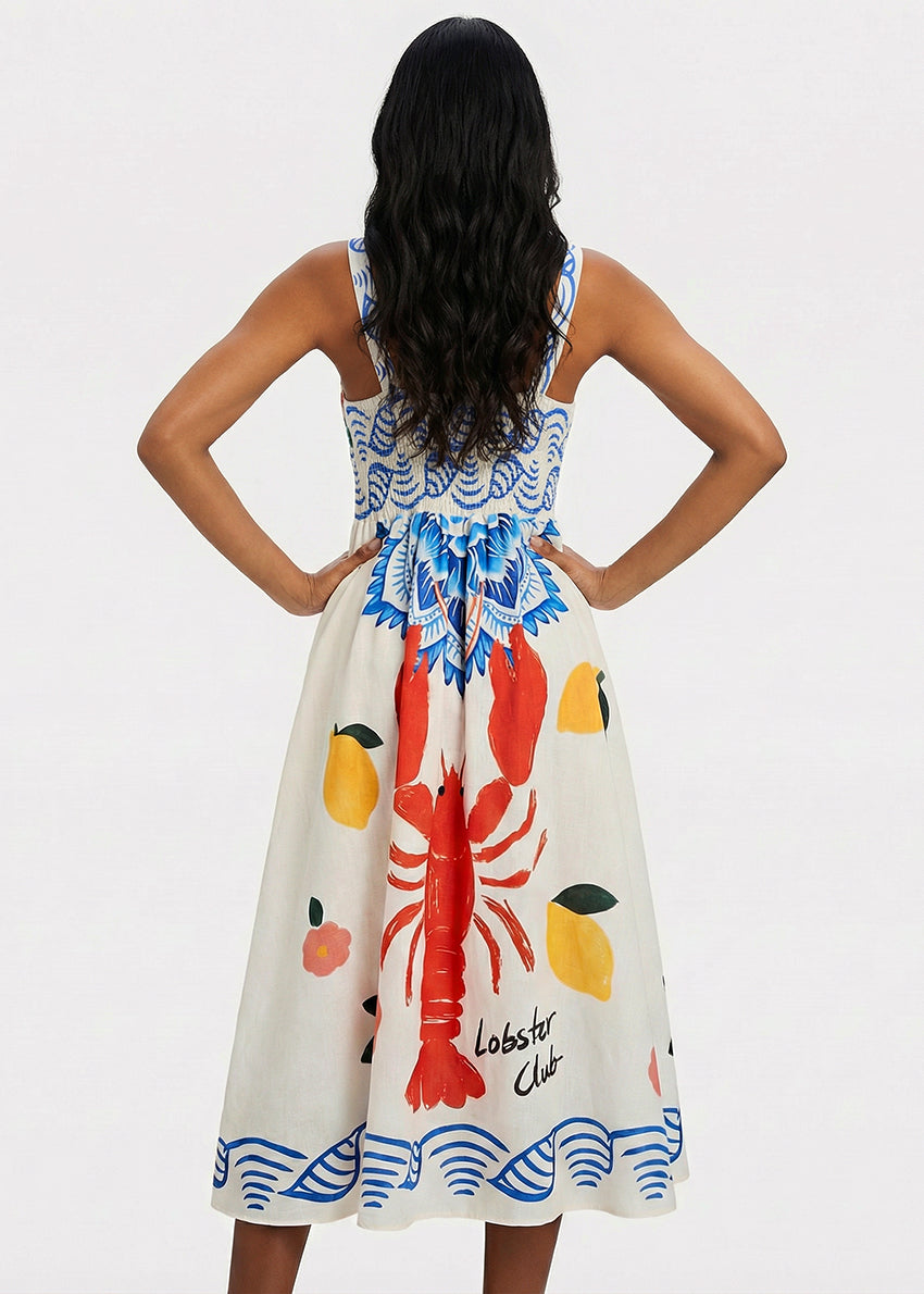 Woman wearing a dress with lobster and lemon design on a plain background