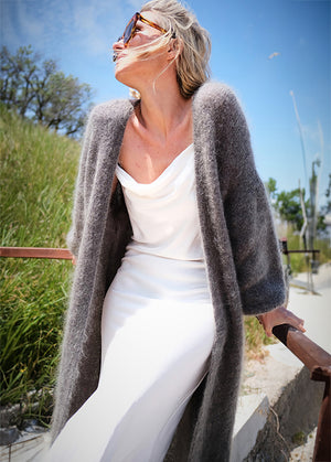 Person wearing a dim grey mohair long cardigan with a white dress