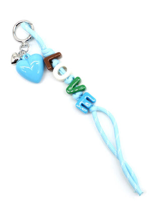Keychain with heart, wooden stick, and 'LOVE' beads on a white background