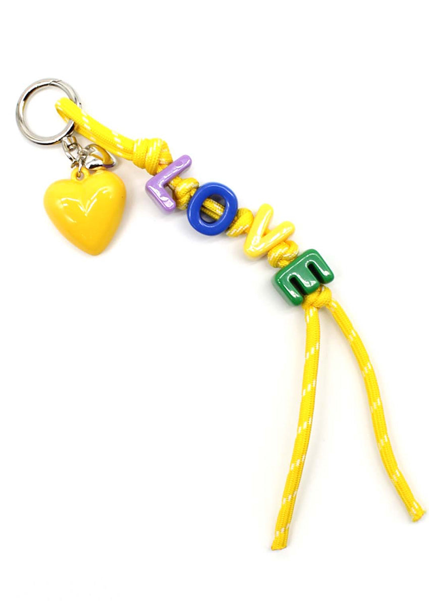Colorful keychain with heart, letters, and green letter 'M' on a white background