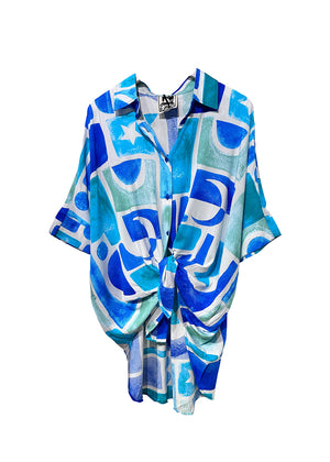 This shirt features a boyfriend-cut shirt which combines an oversized fit with a mediteranean flair, making it a versatile addition to any outfit. Its design includes a collar detail and long sleeves with oversized cuffs, allowing for effortless styling