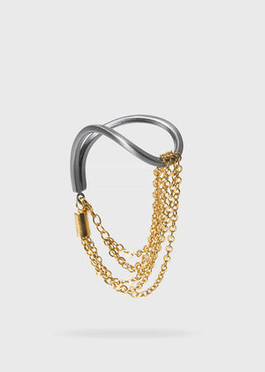The epitome of modern elegance. A thin, metallic rod with inspired curves coexists with a delicate chain in a piece of jewellery that impresses with its ingenious design. Modern finesse in a bracelet that adds glow and sophistication to the look. 