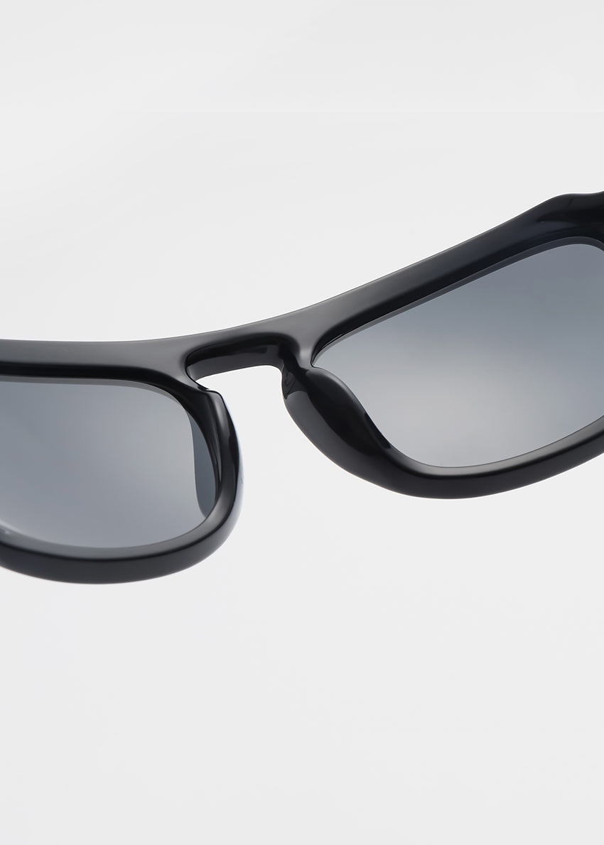 Black sunglasses with reflective lenses on a light gray background