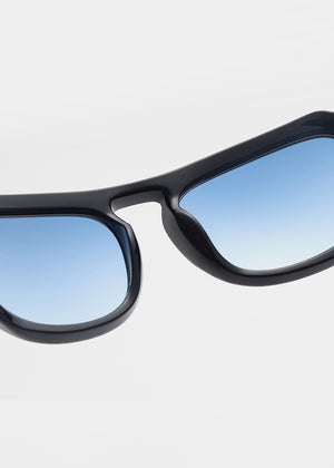 Black sunglasses with blue-tinted lenses on a light gray background
