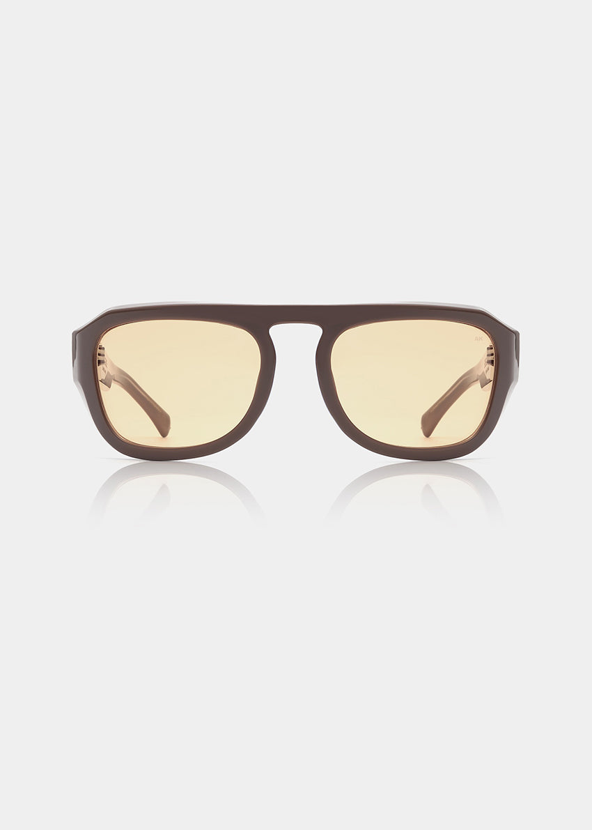 Sunglasses with brown frame and yellow-tinted lenses on a white background