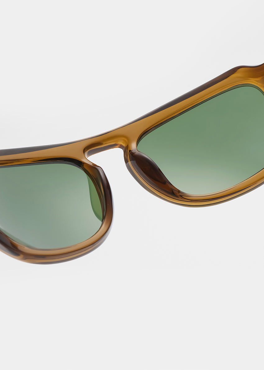 Sunglasses with brown frame and green gradient lenses on a light gray background