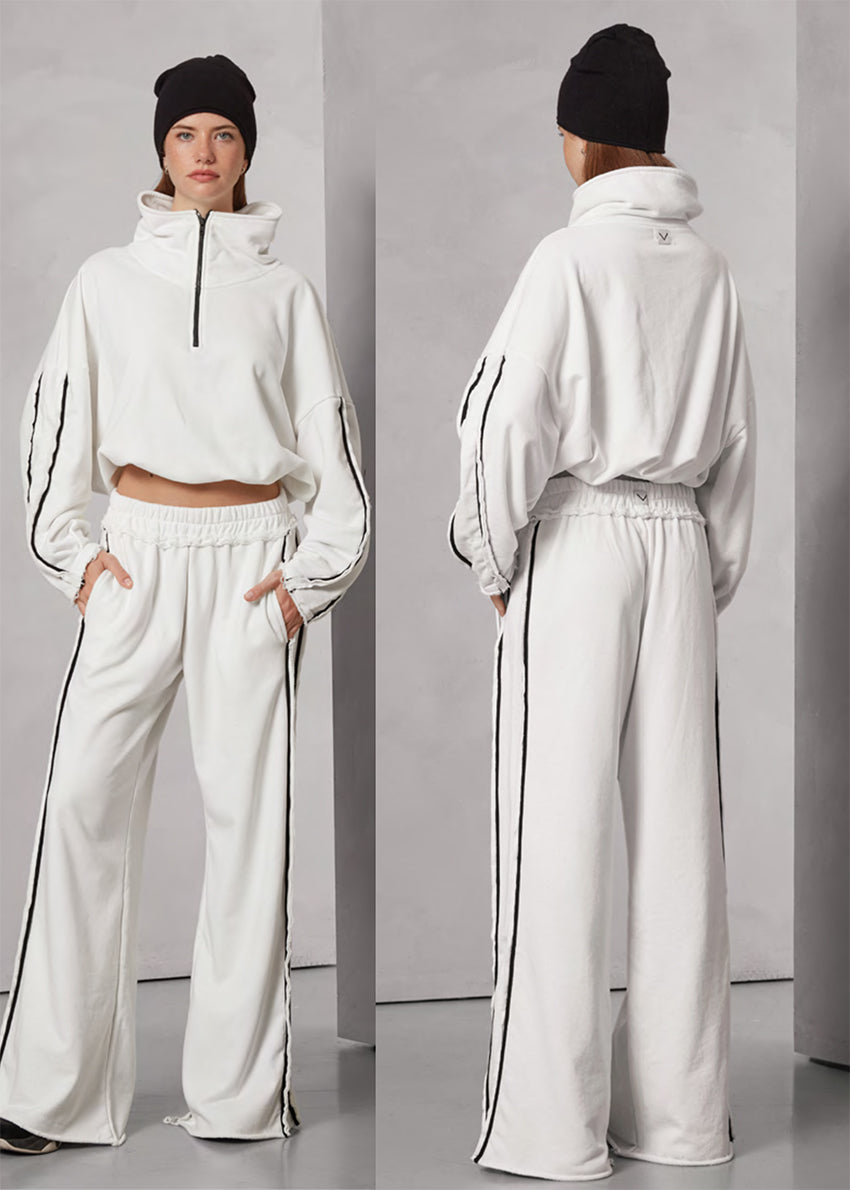 White tracksuit with black stripes worn by a person, shown from front and back on a gray background.